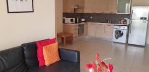 a living room with a couch and a kitchen at Mazotos Panoramic Village in Mazotos