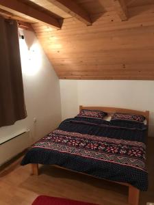 een bed in een kamer met een houten plafond bij Mountain House Vinko in Blidinje