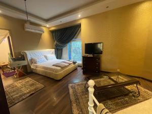a bedroom with a bed and a tv and a table at Royal Mariout Villa in King Mariout