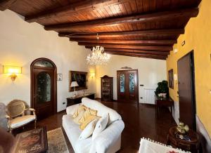 sala de estar con sofá blanco y lámpara de araña en Oasi Dell'Hangar, en Augusta