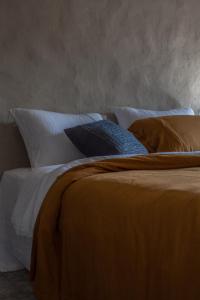 a bed with several pillows on it in a room at Dechiu in Hoi An