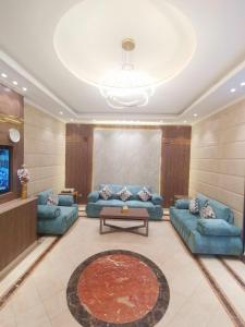 una sala de estar con sofás azules y una mesa. en سارة للشقق المفروشة - الحمدانية جدة en Ḩayy aş Şāliḩīyah