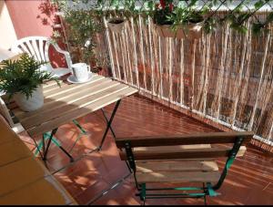 a bench and a table on a balcony with plants at Spacious family flat centrally located. in Palamós