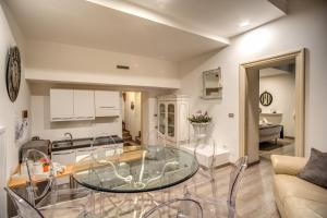a kitchen and living room with a glass table at Trevi Miracle Suite in Rome