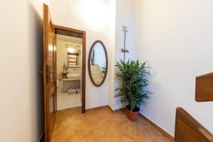 pasillo con baño con espejo y planta en Casa del Geco - La natura intorno a te en Camaiore