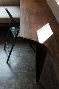 a wooden table and a chair with a piece of paper on it at Dechiu in Hoi An