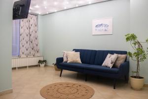 a living room with a blue couch and a tv at Meteor Family Hotel in Chepelare