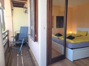 a bedroom with a mirror and a bed and a chair at Vista dolce - Wohnung mit fabelhaftem Blick über die Dächer von Brissago in Brissago