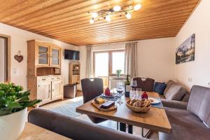 RückholzにあるTrollenhof im Allgäu - Ferienwohnungen Aggensteinのテーブルとソファのあるリビングルーム