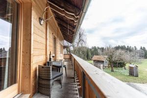 a balcony of a house with chairs and a window at Trollenhof im Allgäu - Ferienwohnungen Aggenstein in Rückholz