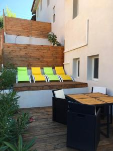 un patio con mesa y sillas amarillas y verdes en L'Estaque -les instants Charline, en Martigues