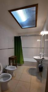 uma casa de banho com 2 WC, um lavatório e uma clarabóia em Casa en Bosque Peralta Ramos em Mar del Plata