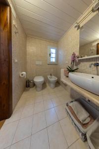 y baño con bañera, aseo y lavamanos. en Casa del Geco - La natura intorno a te en Camaiore