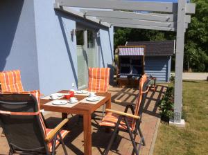 a wooden table and chairs on a patio at Haus TimpeTe am Breetzer Bodden in Vieregge