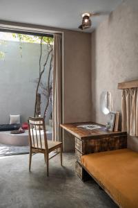 a bedroom with a desk and a chair and a bed at Dechiu in Hoi An