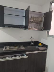 een keuken met een wastafel en een fornuis top oven bij Hermoso aparta estudio con Aire Acondicionado en un primer piso Cerca al Hospital de Neiva in Neiva