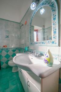 a bathroom with a sink and a mirror and a toilet at Sole Holiday House in Pontone