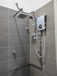 y baño con ducha y cabezal de ducha. en BB D'VELODROM Homestay Dungun, en Dungun