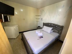 a small bedroom with a bed with white sheets at Hotel Balmoral in Bucaramanga