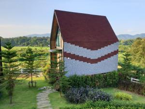 a small building with a red roof on a field at Oxy Resort in Ban Mai Phatthana