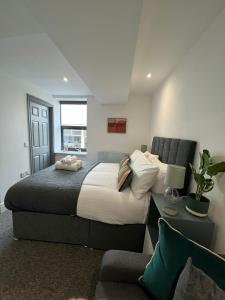 a bedroom with a large bed and a couch at Guest Homes - Eign Street Apartments in Hereford