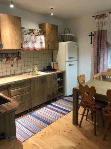 a kitchen with a table and a white refrigerator at Chalupa Soľ nad zlato in Lazisko