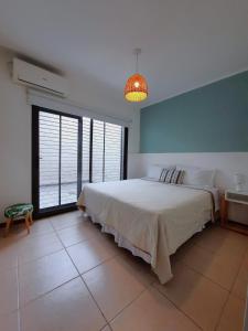 a bedroom with a large bed and a large window at Departamentos René in Ciudad Lujan de Cuyo