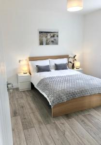a white bedroom with a bed and two night stands at Spacious En-suite Private Double Bedroom in Oxford