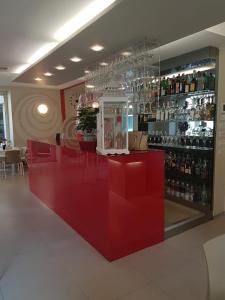 a restaurant with a red counter with red chairs at Hotel Cumilì in Capo di Ponte