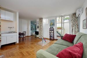 ローマにあるLovely Apartment Via Sistinaのリビングルーム(緑のソファ付)、キッチンが備わります。