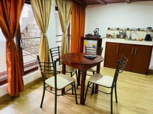 cocina con mesa y sillas y cocina con ventana en Hermoso apartamento en Baños de Agua Santa, en Baños