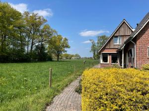 een bakstenen pad naar een huis in een veld bij Bed and Breakfast De Beekhoek in Glane