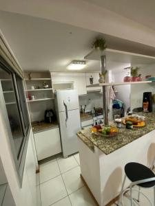 cocina con nevera blanca y encimera en Miniduplex bem localizado, en Brasilia