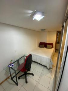 1 dormitorio con 1 cama, mesa de cristal y silla en Miniduplex bem localizado, en Brasilia