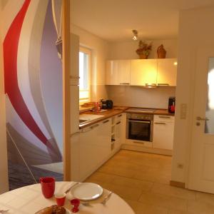 a kitchen with white cabinets and a table and a flag at Haus TimpeTe am Breetzer Bodden in Vieregge