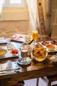 uma mesa coberta com pratos de comida e copos de sumo de laranja em Il-Logga Boutique Hotel em Xaghra