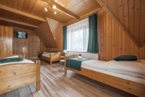 a bedroom with two beds in a wooden cabin at Tatrzański 22 - Komfortowy dom w górach in Leśnica
