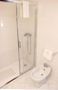 a white bathroom with a shower and a toilet at Casa da Reina in Viana do Castelo