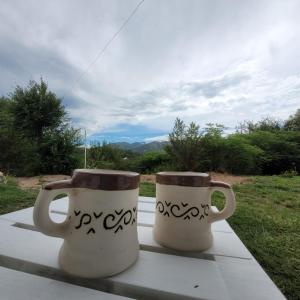 dos tazas de café sentadas sobre una mesa en Bella Vista en Valle Hermoso