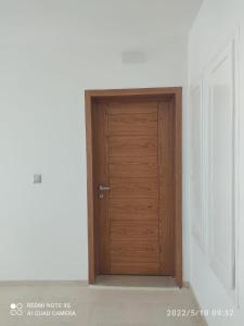eine Holztür in einem leeren Raum in der Unterkunft Belle appartement vue de mer in Zarzis
