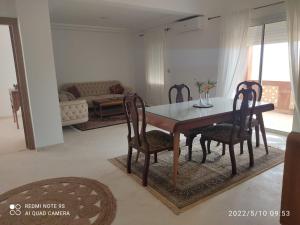 a dining room table and chairs in a living room at Belle appartement vue de mer in Zarzis