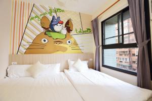 a bedroom with a white bed and a window and a painting at Taichung FJ Victoria in Taichung