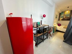 einen roten Kühlschrank in einem Zimmer mit einem Schlafzimmer in der Unterkunft Estudio Jardines de Colón in Córdoba