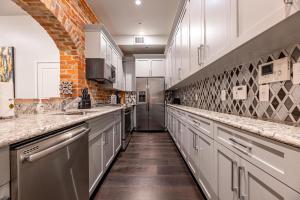 a large kitchen with white cabinets and a brick wall at The Crescent in New Orleans