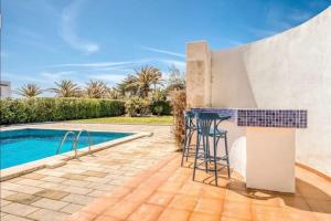 a patio with a bar next to a swimming pool at LA CALMA Espectacular villa con jardín y piscina en Menorca in S'Algar