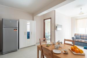 una cucina e una sala da pranzo con tavolo e frigorifero di Solemar Sicilia - Casa Butera a Bagheria