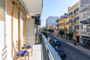 un balcone di un edificio con sedie e una strada di Solemar Sicilia - Casa Butera a Bagheria