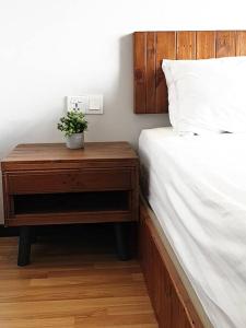 een slaapkamer met een bed en een nachtkastje met een plant erop bij Mahkota Pool View Apartment near A’Famosa & Jonker in Melaka