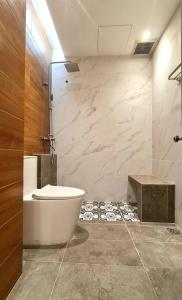 La salle de bains est pourvue de toilettes et d'une douche en verre. dans l'établissement Mahkota Pool View Apartment near A’Famosa & Jonker, à Malacca
