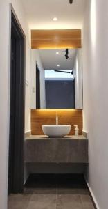 La salle de bains est pourvue d'un lavabo et d'un miroir. dans l'établissement Mahkota Pool View Apartment near A’Famosa & Jonker, à Malacca